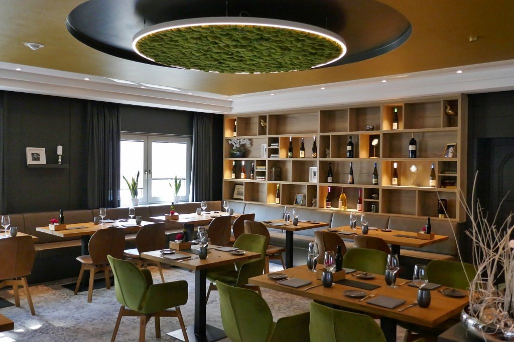 Warme Restaurantatmosphäre mit gedecktem Tisch und Kerzenlicht.